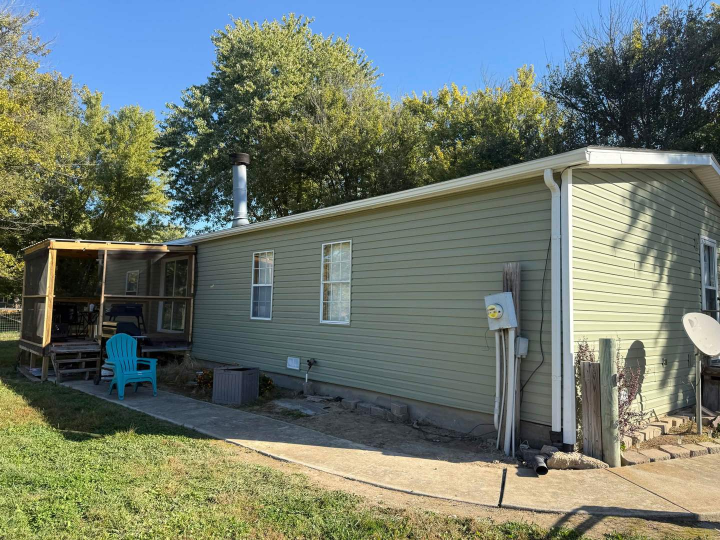 Completed vinyl siding alongside a screened porch, showing clean panel lines and trim