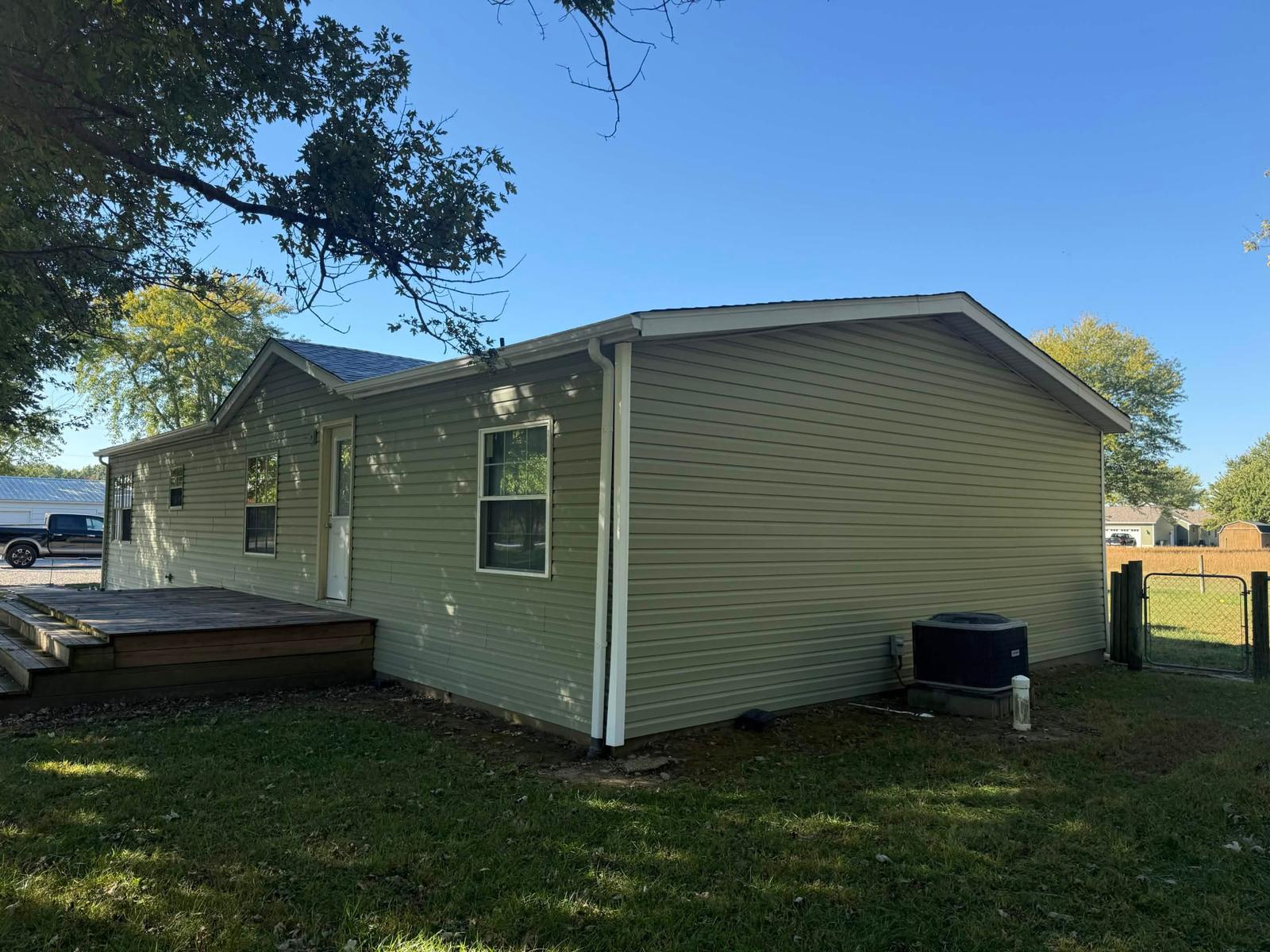 Rear corner of the completed siding project with new guttering and downspout
