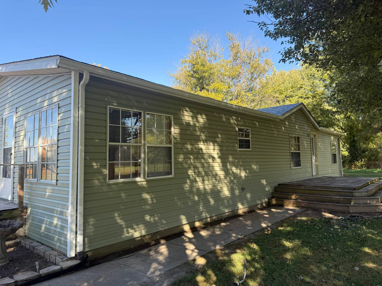 Side elevation of a home with newly installed vinyl siding and white fascia